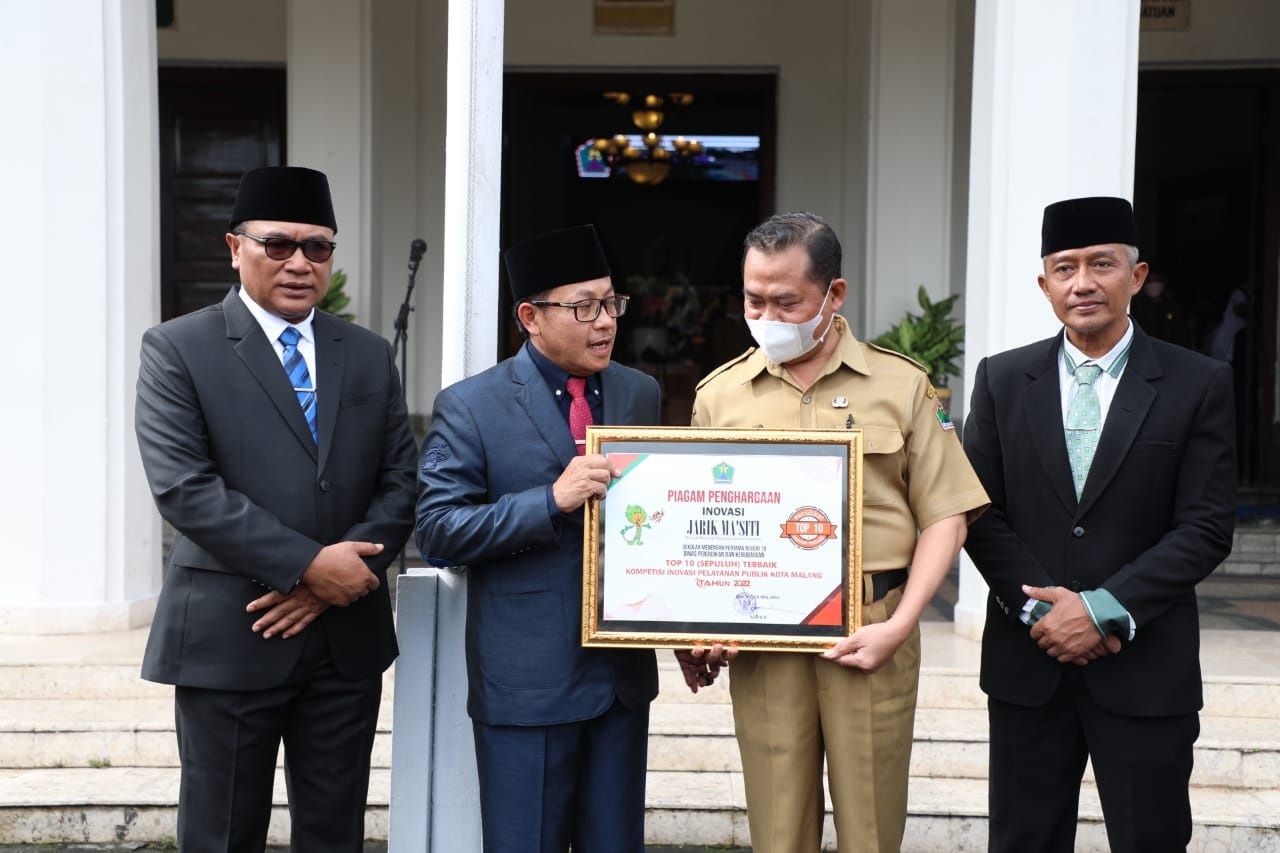 Wali Kota Malang Sutiaji menyerahkan penghargaan pada inovator Jarik Ma'siti didampingi Wakil Wali Kota Malang Sofyan Edi Jarwoko (kiri) dan Sekda Erik Setyo Santoso di Balai Kota Malang, beberapa waktu lalu. Foto : Dok. Humas Pemkot Malang