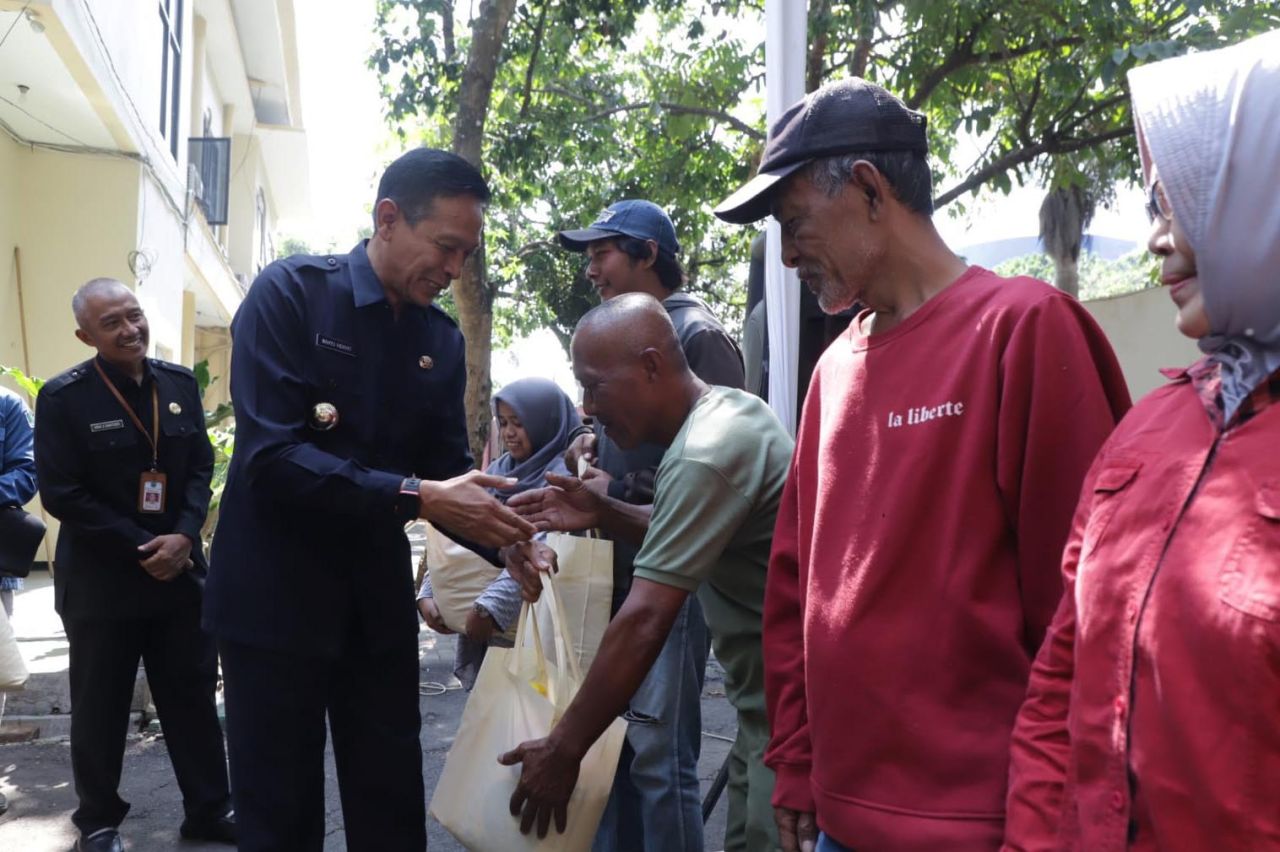 Pj Wali Kota Malang Wahyu Hidayat menyerahkan paket pangan murah kepada warga Kecamatan Kedungkandang, Senin (20/11). Paket berisi beras 5 kg, minyak goreng 2 liter dan satu kg gula. Foto :  Bagian Protokol dan Komunikasi Pimpinan Kota Malang