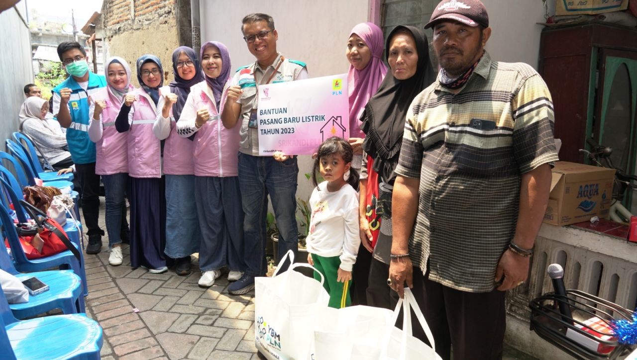 Srikandi PLN didampingi oleh Manager UP3 Surabaya Utara, Bustani Hadi Wijaya secara simbolis berikan pasang baru listrik gratis kepada 3 orang warga kurang mampu di wilayah Kalijudan, Kota Surabaya. (Foto: PLN for Jatimkini.com)