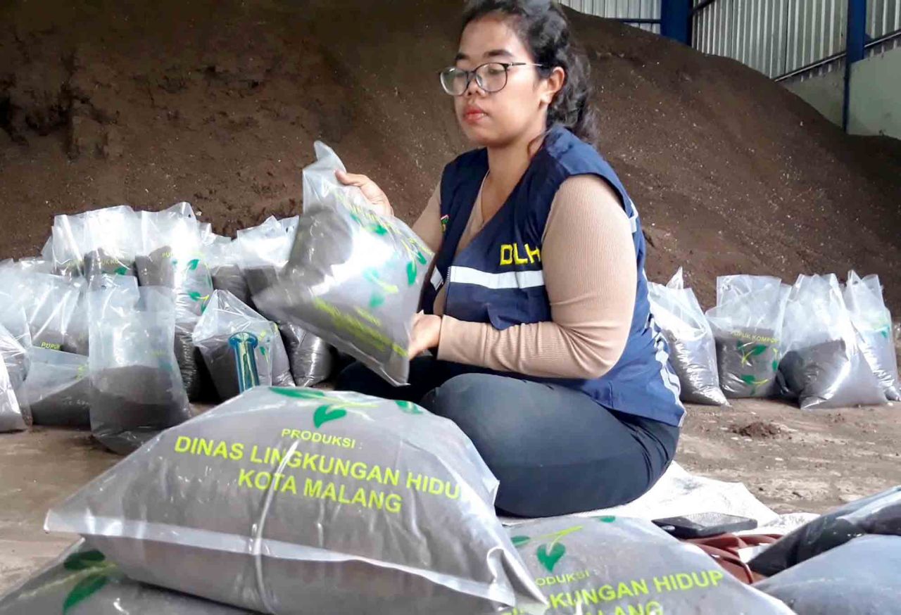 Petugas Dinas Lingkungan Hidup Kota Malang, Fatimah sedang mengemas kompos di Unit Pelaksana Teknis Pengolahan Sampah Supiturang di Kelurahan Mulyorejo, Kecamatan Sukun, Kota Malang, Jumat (1/12). Foto : Jatimkini/Bagus Suryo