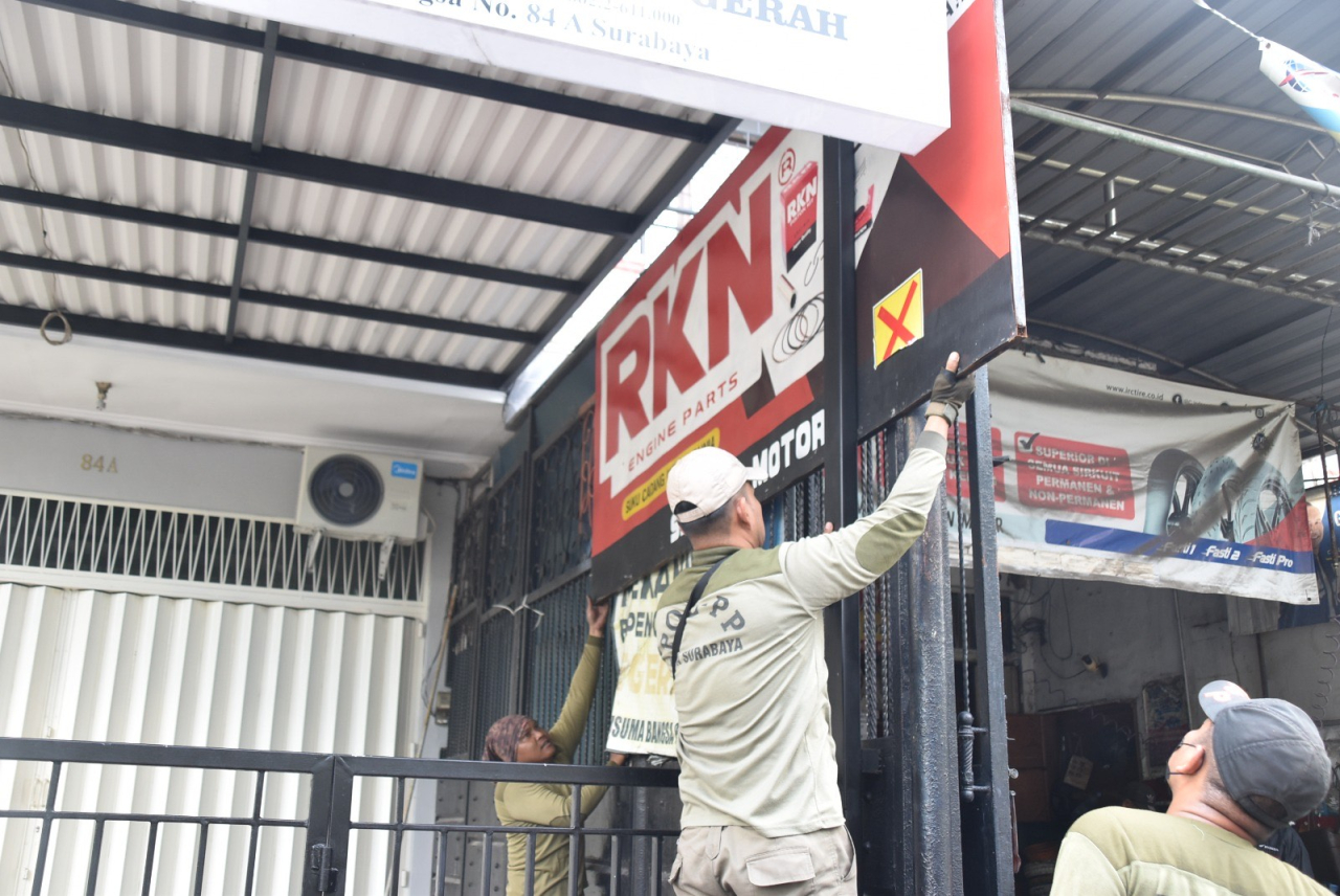 Petugas Satpol PP Surabaya menertibkan reklame tak berizin dan tak bayar pajak. Foto : Pemkot Surabaya for Jatimkini