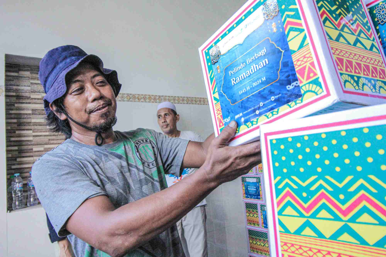 Warga menerima bantuan paket sembako dari Terminal Teluk Lamong. Foto : TTL