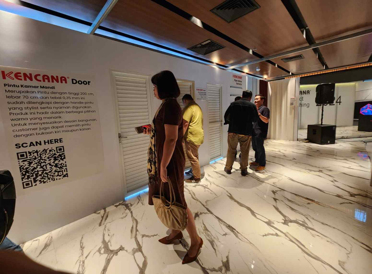 Pengunjung melihat produk pintu kamar mandi Kencana yang terbuat dari baja ringan. Foto : Peni Widarti
