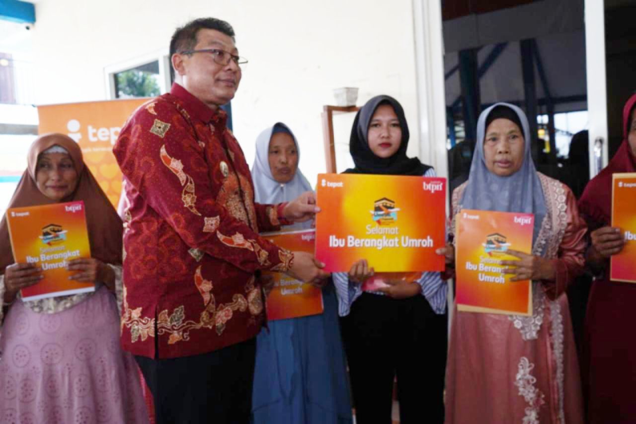Wakil Bupati Malang Didik Gatot Subroto menyerahkan hadiah umrah kepada ibu-ibu nasabah BTPN Syariah warga Singosari di Balai Desa Wonorejo, Kecamatan Singosari, Kabupaten Malang, Kamis (20/6). Foto: Dok. BTPN Syariah