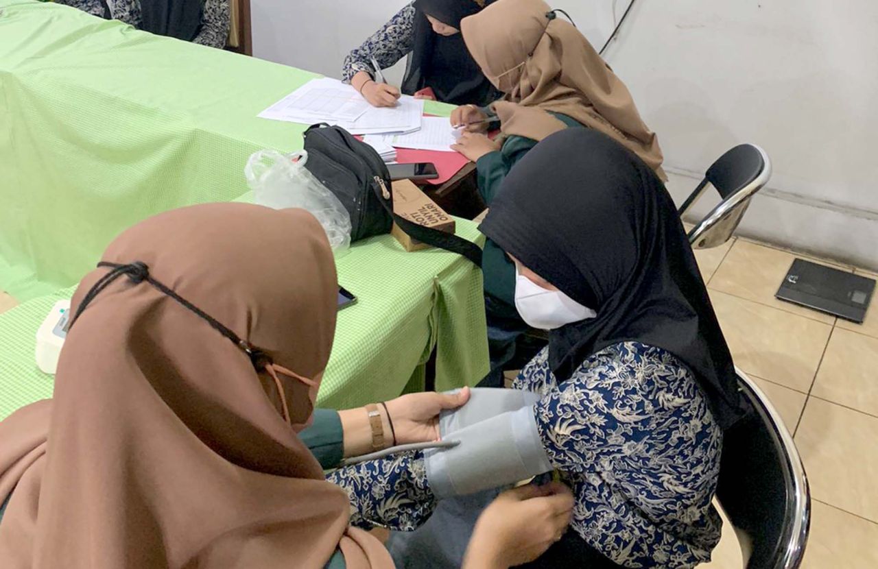 Peneliti Poltekkes Kemenkes Malang, Jawa Timur, Anggun Setyarini, mengecek tekanan darah siswa saat riset penyakit hipertensi di sebuah SMA Kota Malang, beberapa waktu lalu. Foto: Jatimkini/Dok. Anggun Setyarini