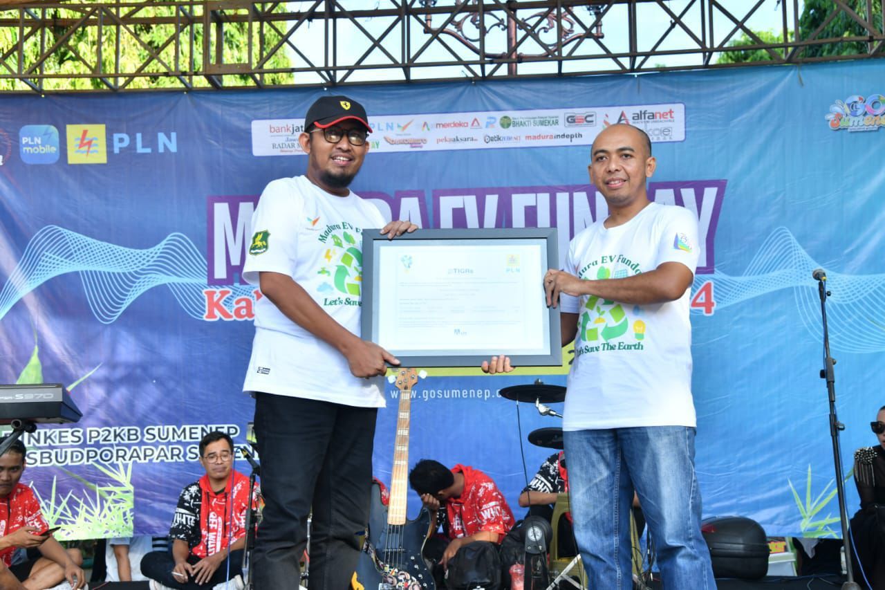 Penyerahan 500 unit REC dari Manager PLN UP3 Madura, Fahmi Fahresi kepada Bupati Sumenep, Achmad Fauzi dalam kegiatan Madura EV Day. (Foto: PLN for Jatimkini)