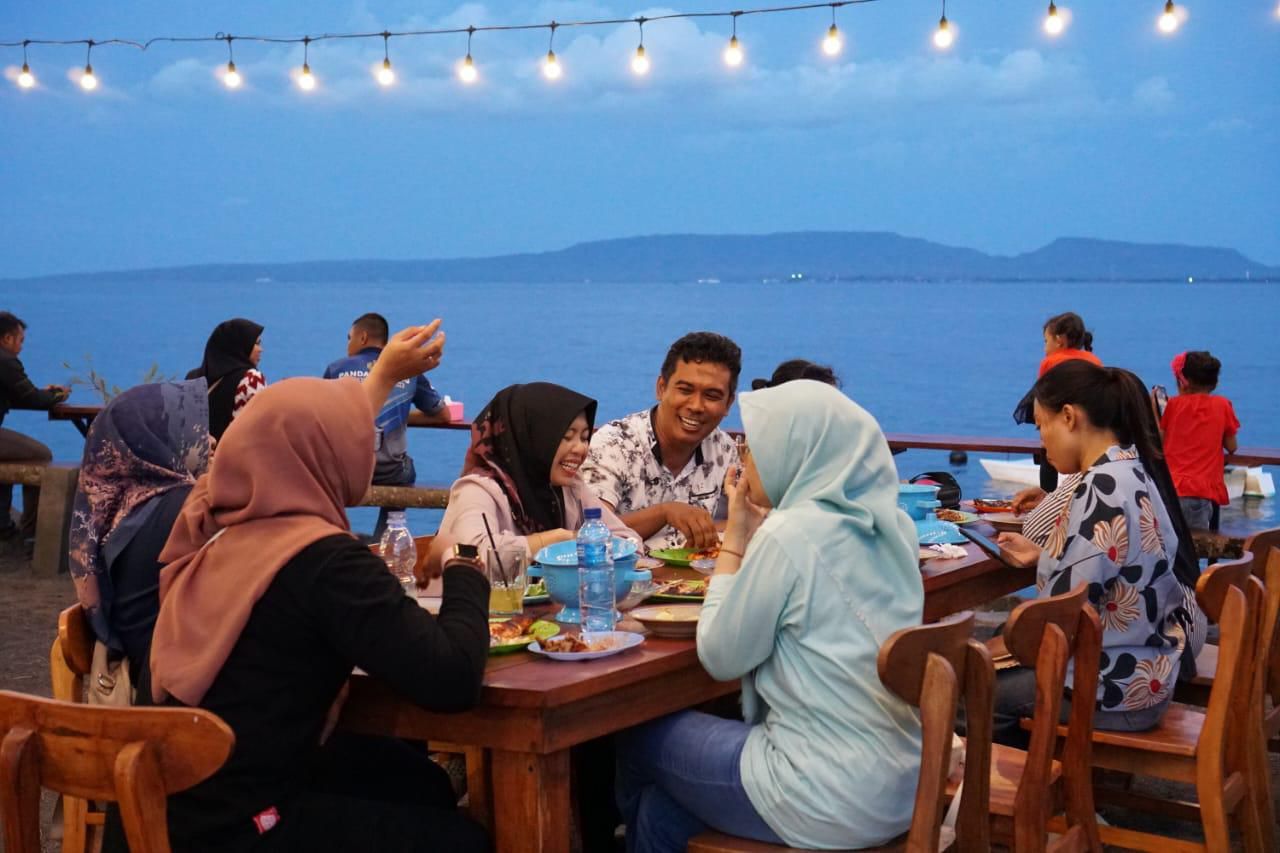 Pengunjung saat menikmati makanan  di kawasan Pantai Boom, Banyuwangi. (Foto: PLN for Jatimkini)
