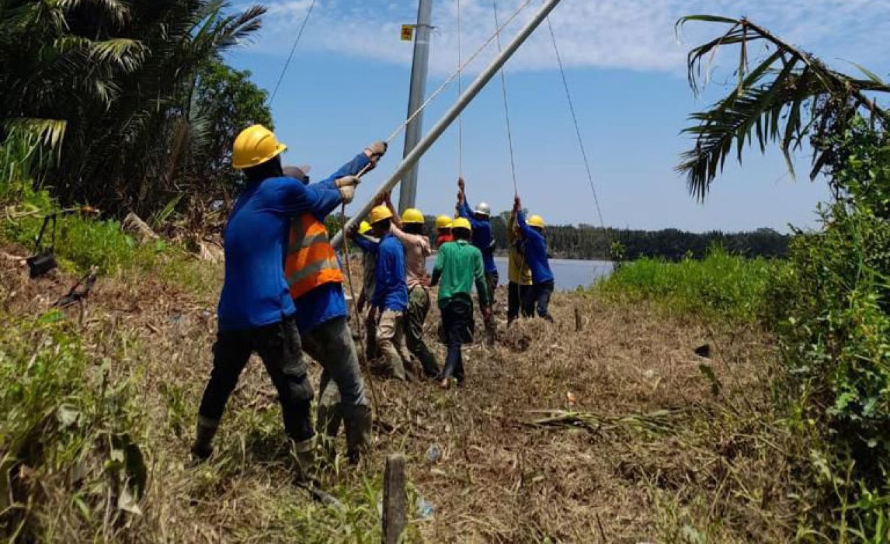 Personel PLN memasang aliran listrik di kabupaten sintang kalimantan barat. (Foto: PLN for Jatimkini)
