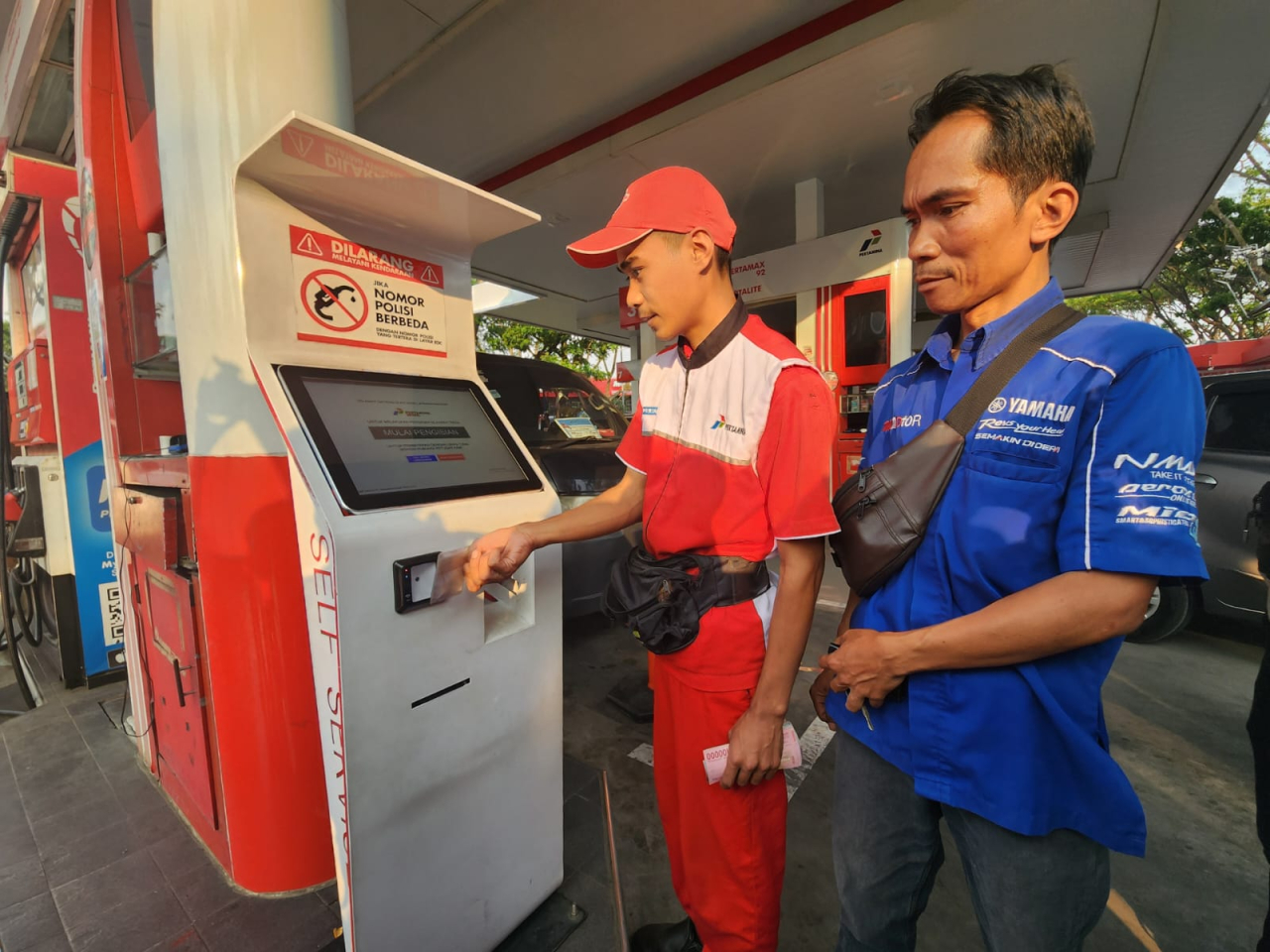 Petugas SPBU di Padaralang Bandung, Jawa Barat sedang melayani scan barcode milik pelanggan BBM subsidi. Foto : Peni Widarti