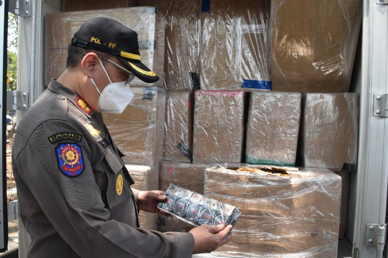 Petugas mengumpulkan kardus rokok yang diduga tidak dilengkapi pita cukai.