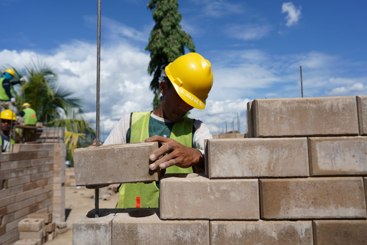 Proses pemasangan inovasi produk turunan semen hijau SIG precise interlock brick dalam pembangunan hunian tapak rumah lingkungan tipe 36 di IKN. Foto : SIG