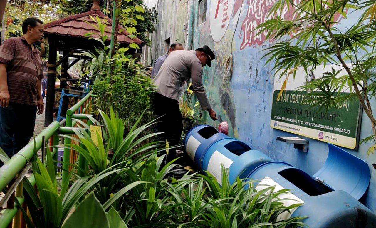 Kapolsek Sidoarjo Kota, AKP Ega Prayudi meninjau ternak lele dari tong bekas di Kampung Edukasi Sampah, Sidoarjo. (foto-foto: KES for jatimkini.com)