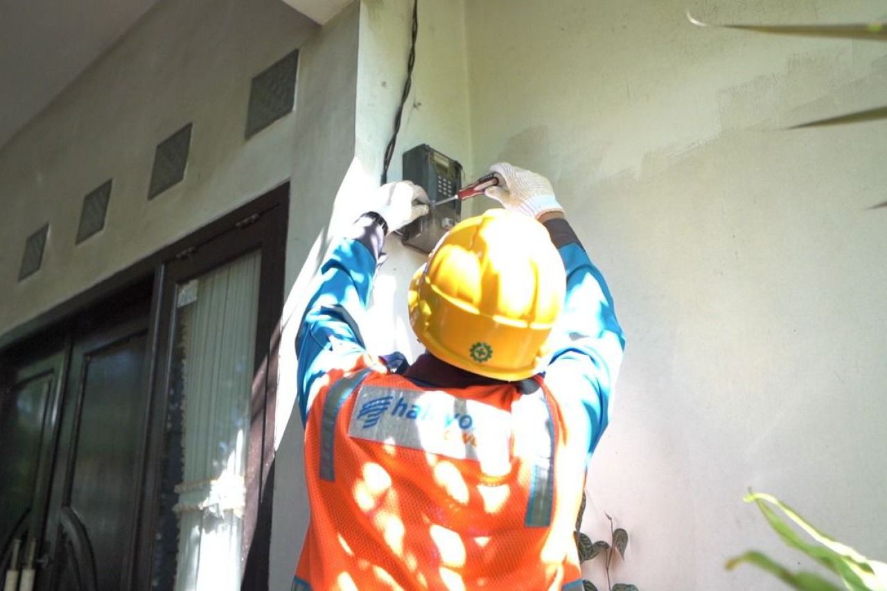 Ilustrasi: Petugas PLN saat melakukan penambahan daya pada kWh meter milik pelanggan. (Foto: PLN for Jatimkini)