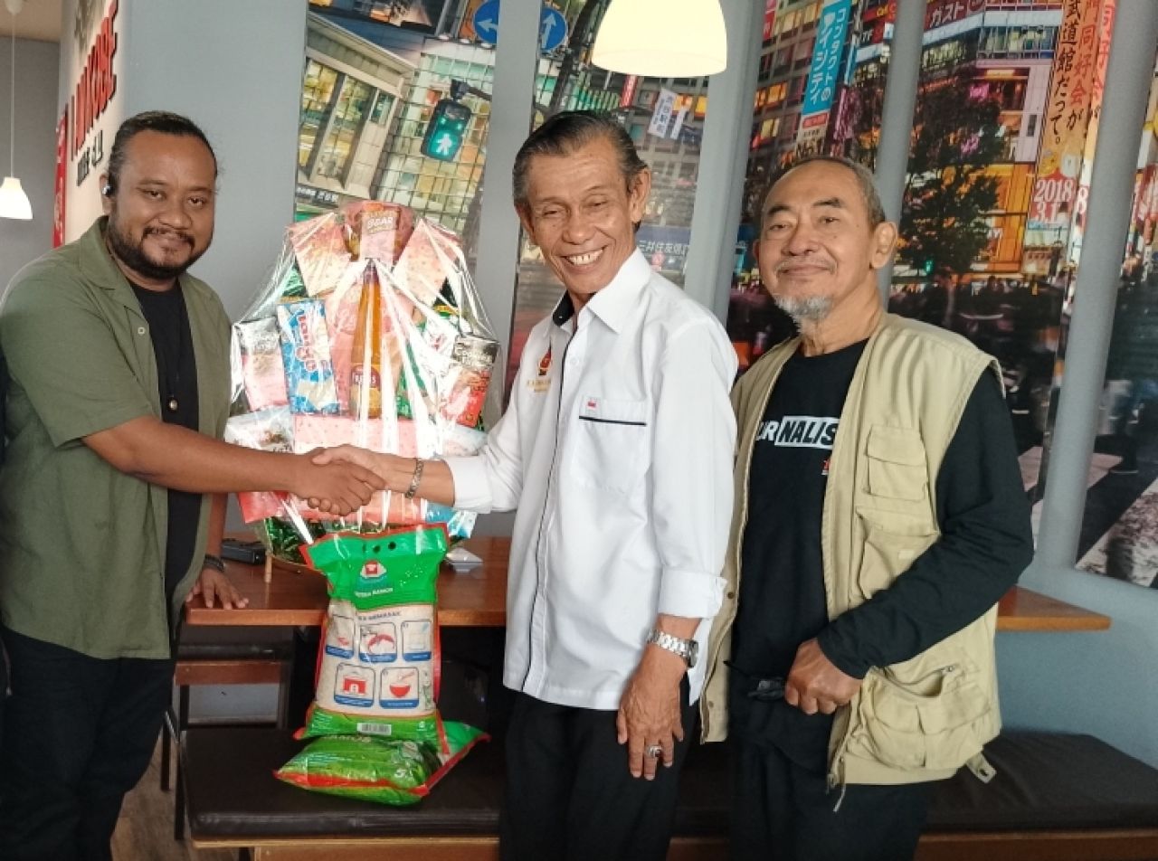 'Ade' Slamet Maulana menyerahkan bingkisan Hari Pers 2025 kepada Yousri Nur Raja Agama disaksikan oleh Darmantoko. (Foto:  Jatimkini.com/Rokimdakas)