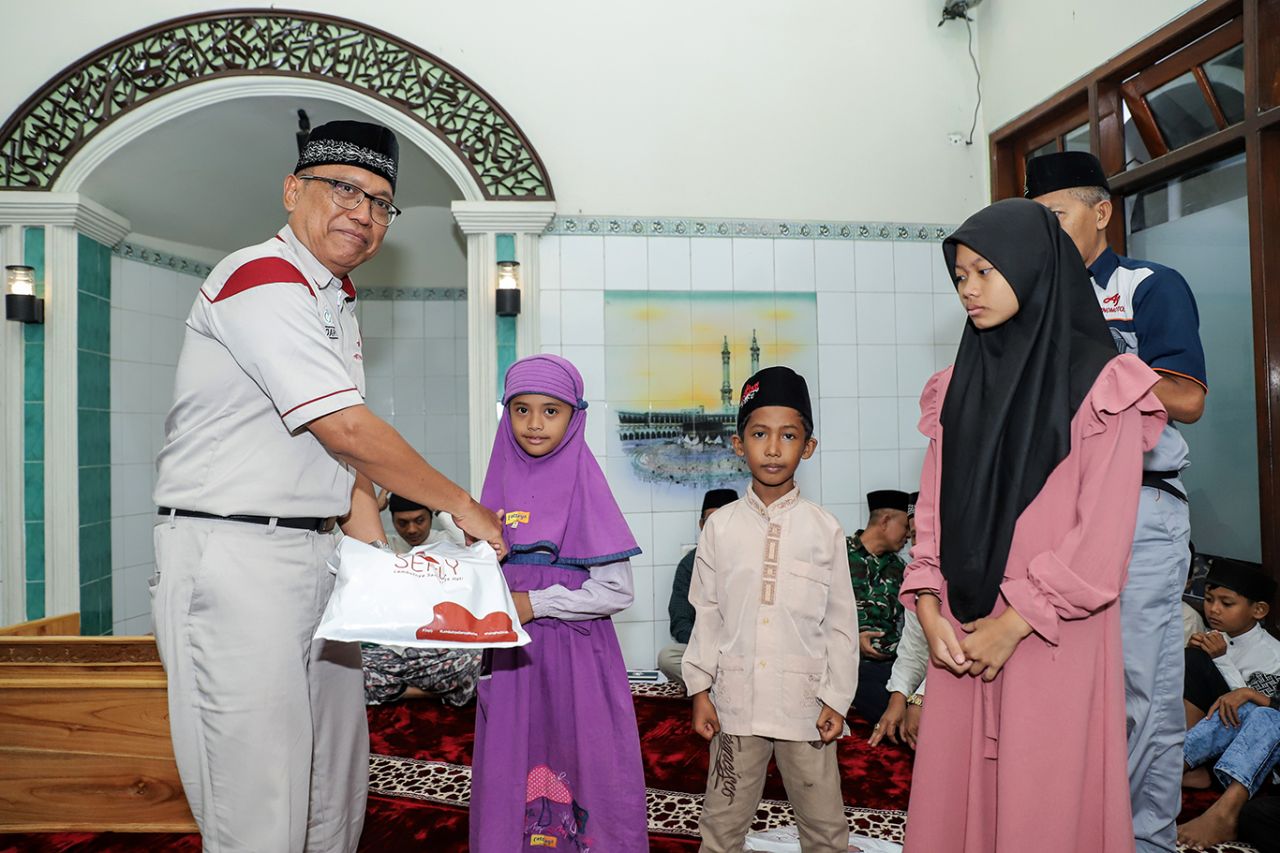 Board of Director di Grup Ajinomoto Indonesia, Daru Puspito membagikan bingkisan kepada warga di sekitar industri sebagai bagian dari CSR.