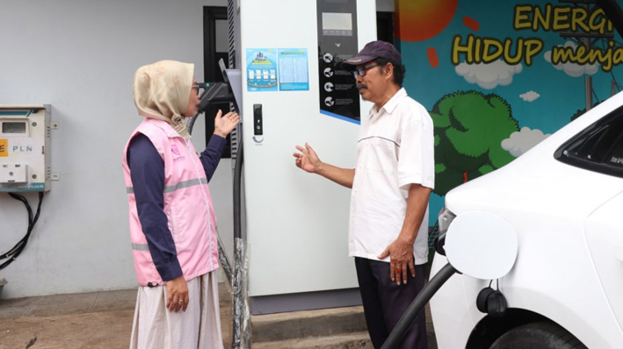Estuning Rahayu (kiri), Srikandi PLN ketika melayani pelanggan yang  hendak mengisi daya kendaraan listrik pada periode arus balik mudik lebaran 1446 H.