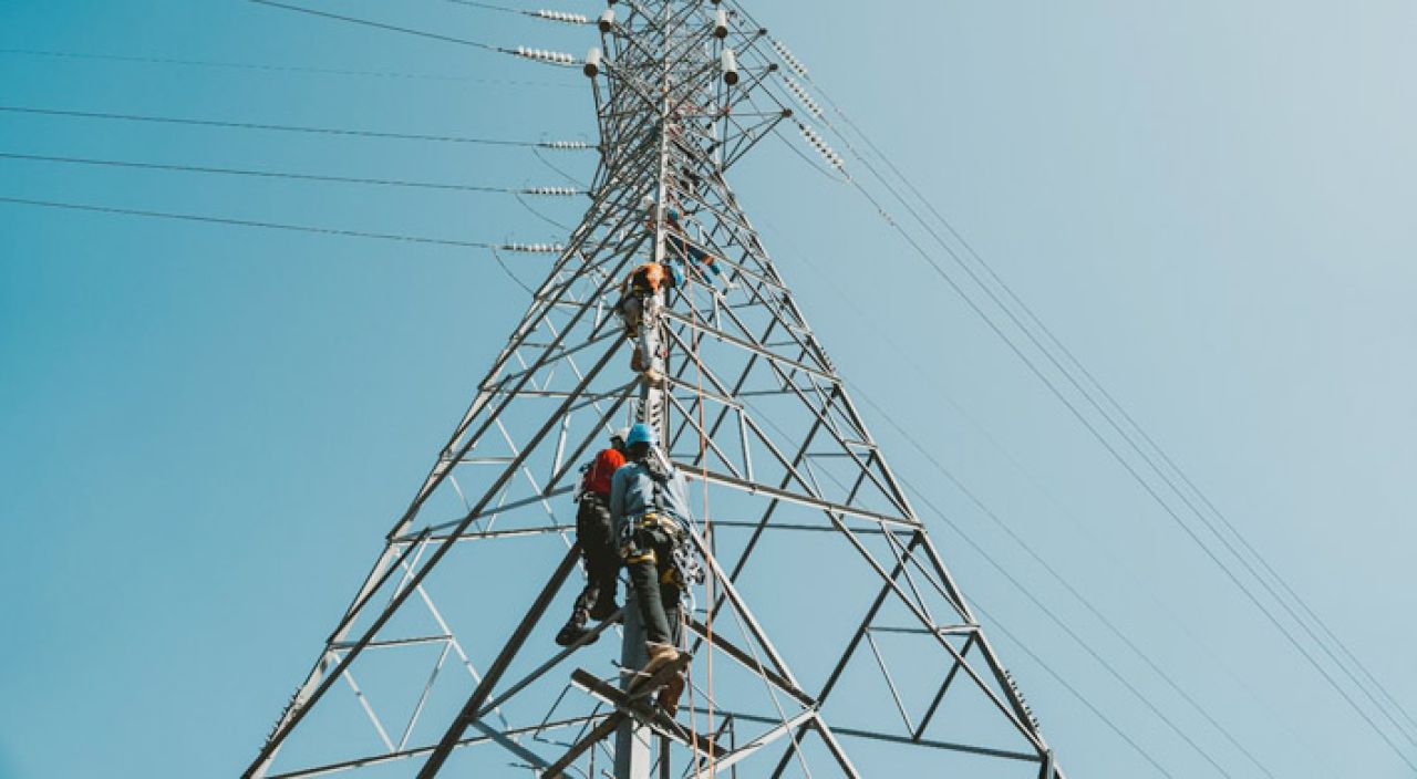 Petugas PLN ketika melakukan pengecekan pada tower transmisi demi menjaga keandalan listrik.