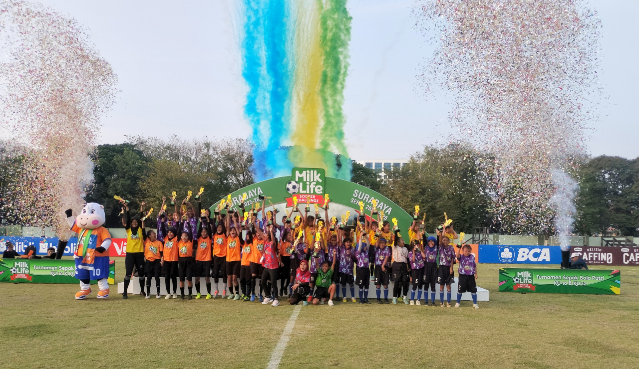 Para juara MilkLife Soccer Challenge Surabaya 2025 rayakan kemenangan di atas podium dengan penuh kebanggaan.