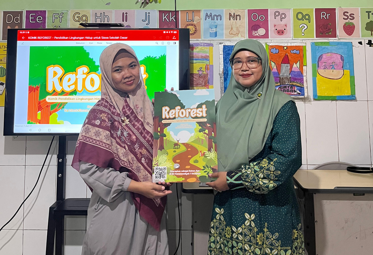 Dosen UMSurabaya, Waode Hamsia (kanan) menunjukkan Reforest, komik digital bagi pelajar SD untuk memelajari ekosistem. (Foto: dok.UMSurabaya)