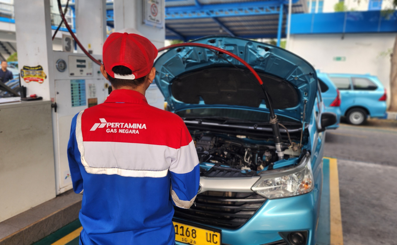 Petugas SPBG Ngagel menunggu proses pengisian Gasku pada tangki gas taksi Blue Bird hingga tangki gas penuh. Foto : Peni Widarti