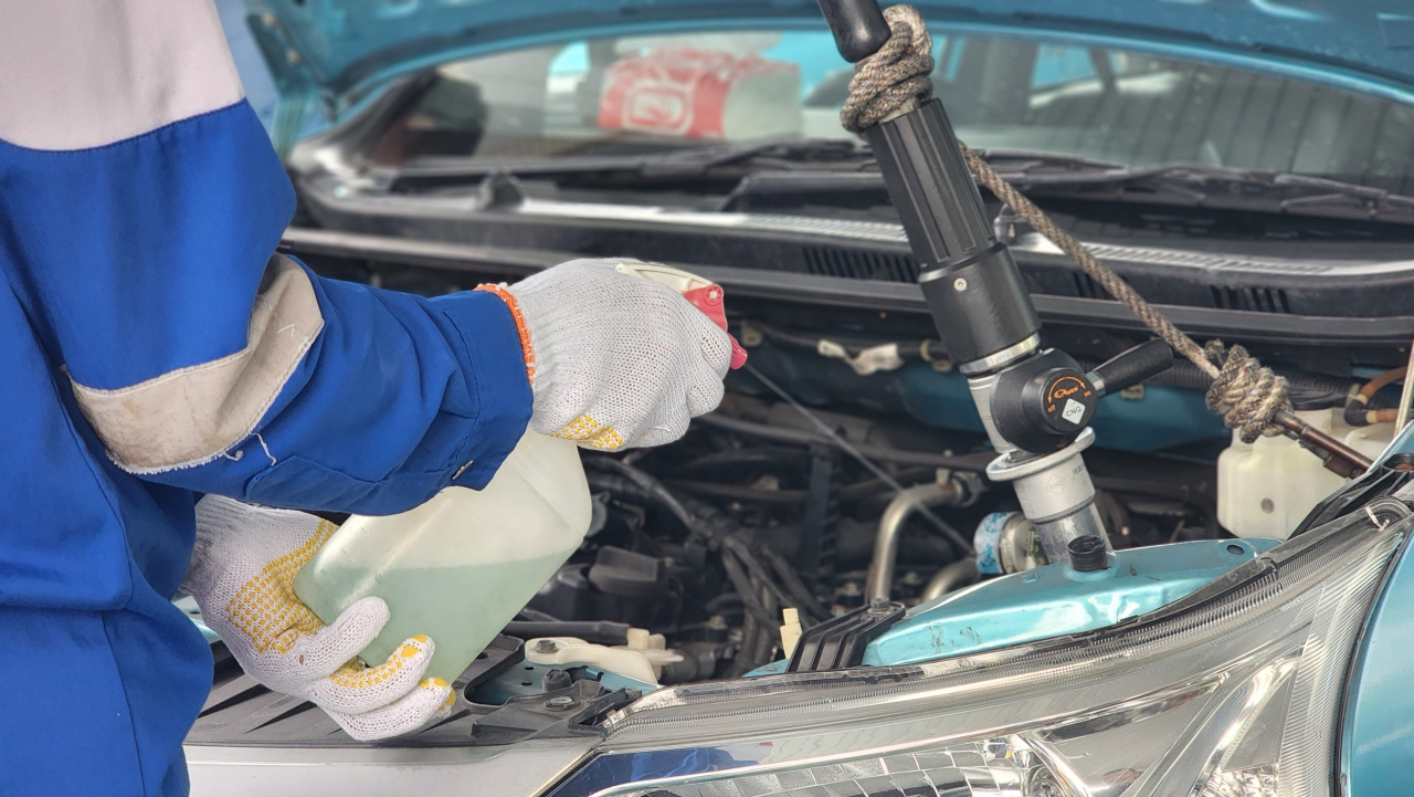 Petugas SPBG Ngagel Surabaya menyemprotkan cairan pada knop tangki BBG mobil taksi Blue Bird sebelum diisi Gasku. Penyemprotan bertujuan untuk mendinginkan tangki yang mengalami panas berlebih akibat meningkatnya tekanan tangki gas seiring dengan kenaikan suhu. Foto : Peni Widarti
