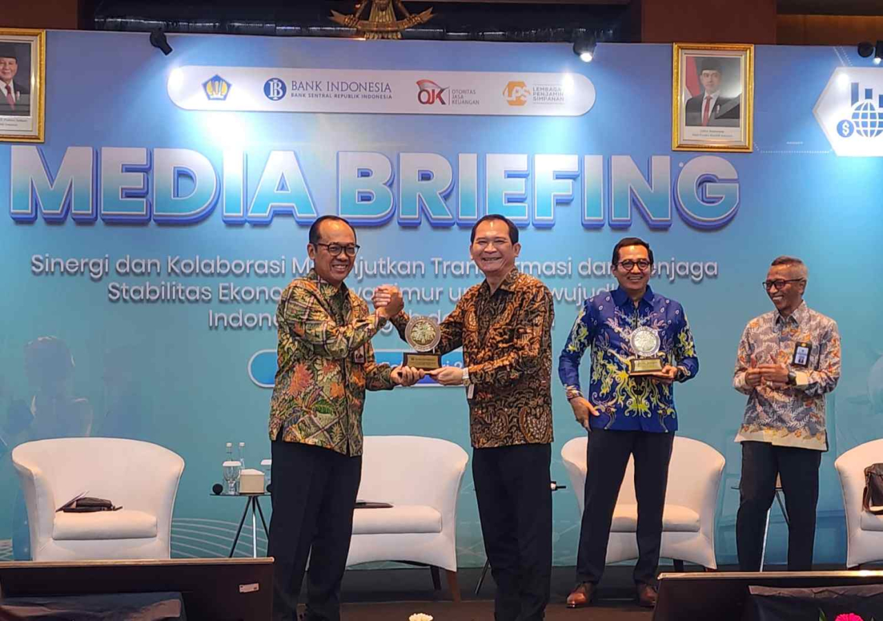 Kepala BI Jatim Ibrahim (kiri) memberikan cinderamata kepada OJK dalam Media Briefing di Surabaya, Senin (9/2/2026). Foto : Peni Widarti