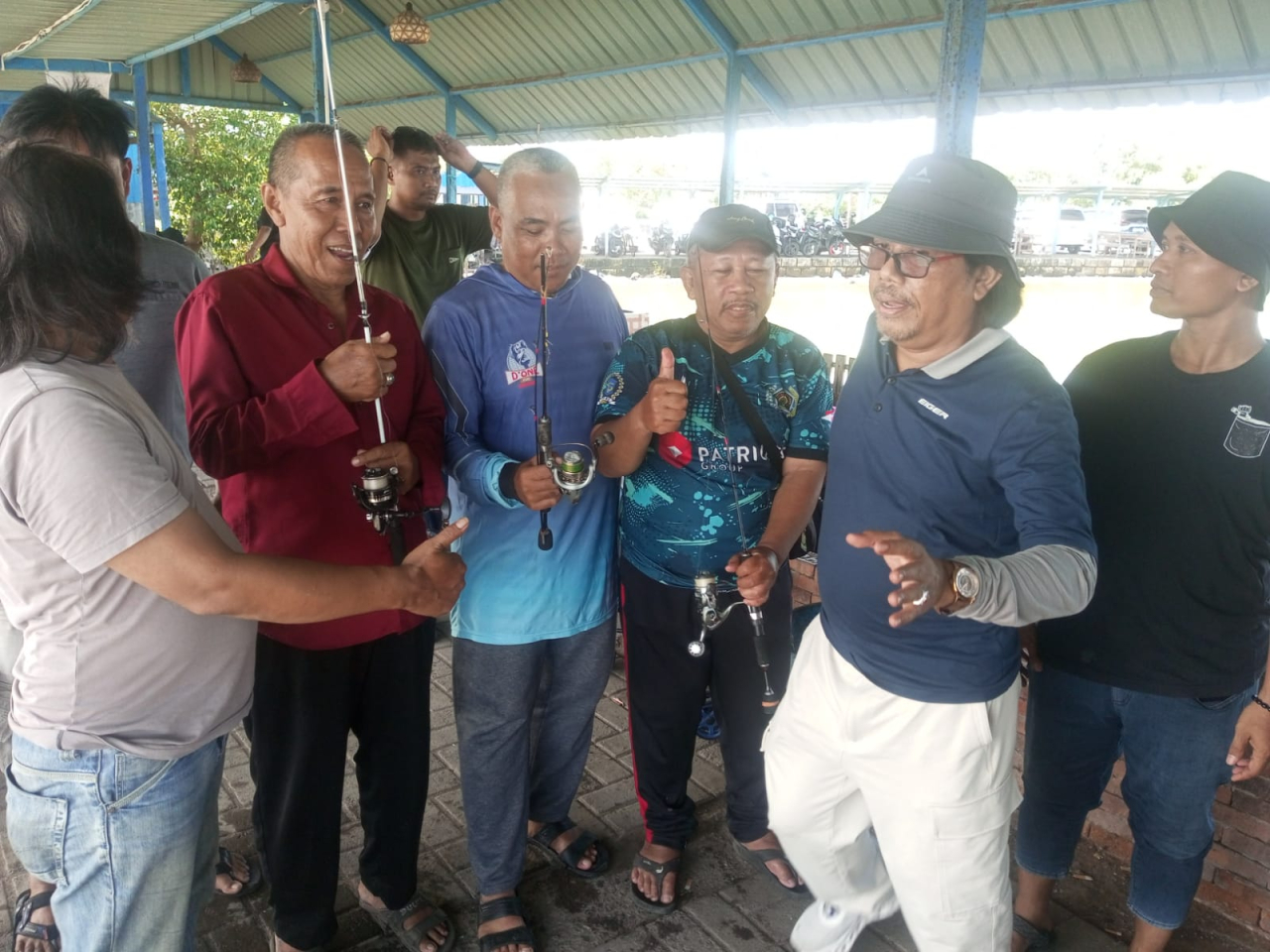 Budi Leksono menyerahkan alat pancing kepada juara adu cepat Mancing Bahagia di Sedati Sidoarjo ( Foto : Soemadji / JatimKini.com )
