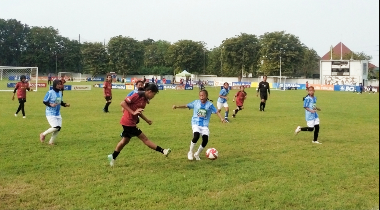 Pemain SDN Manukan Kulon II/499 B menendang bola saat melawan SDN Gubeng 1, di Lapangan Sepakbola Jala Krida Mandala, Sabtu (16/5/2026). Foto: Arif.