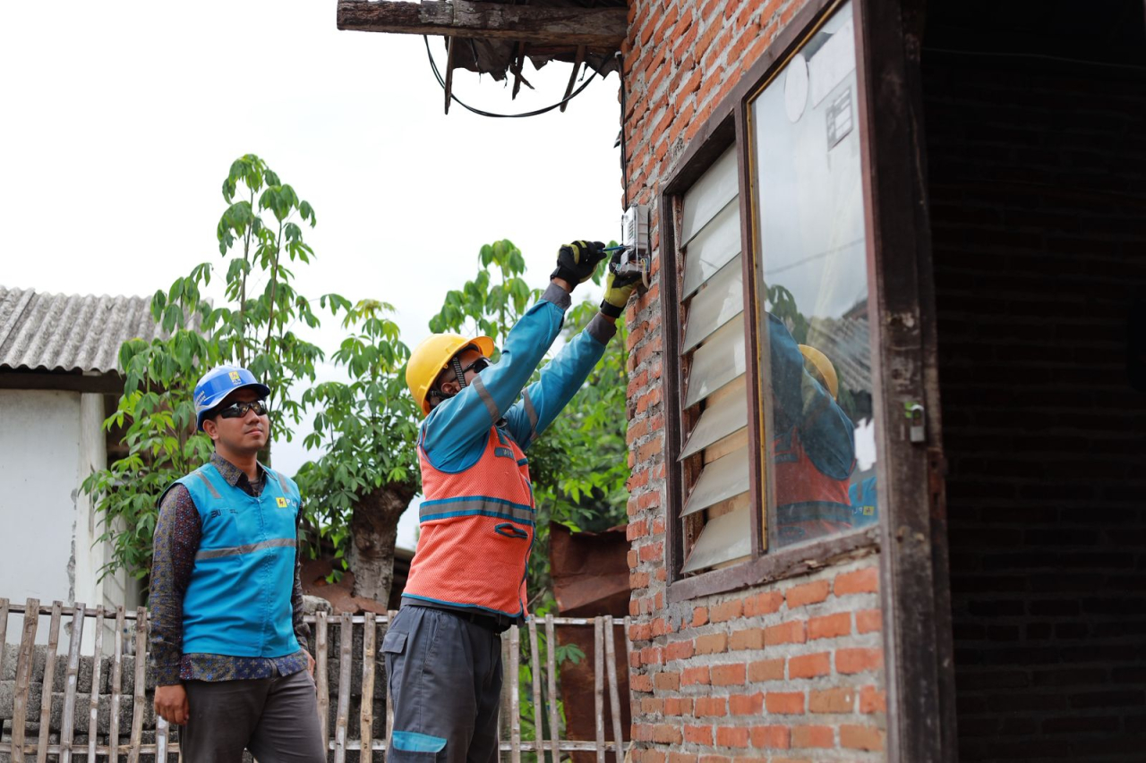 Petugas PLN melakukan pemasangan dan pengecekan meter listrik di salah satu rumah pelanggan di Jawa Timur.