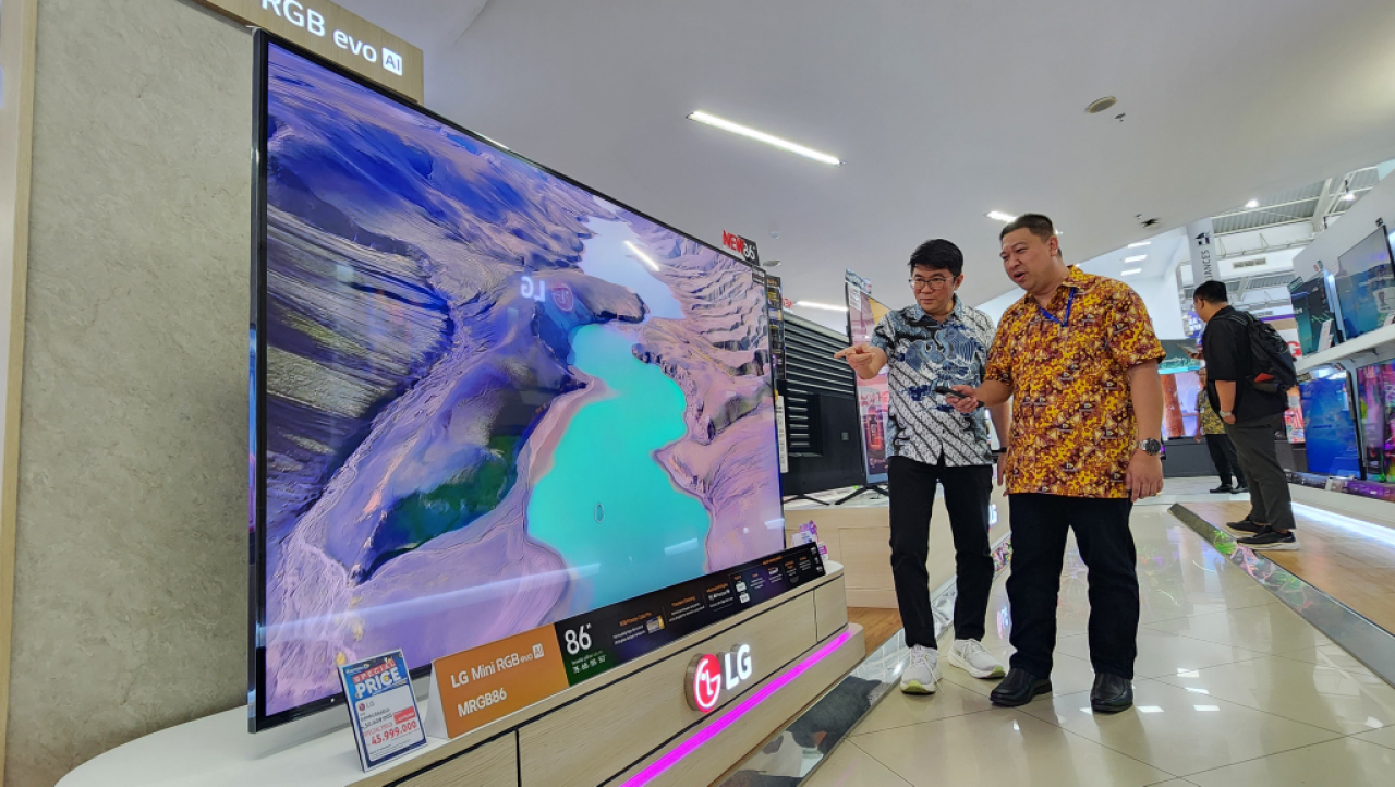 Branch Manager Surabaya LG Electronics Indonesia, Iwan Sutanto (kiri) memamerkan produk TV terbaru LG berbasis AI di gerai elektronik Hartono Surabaya. Foto : Peni Widarti