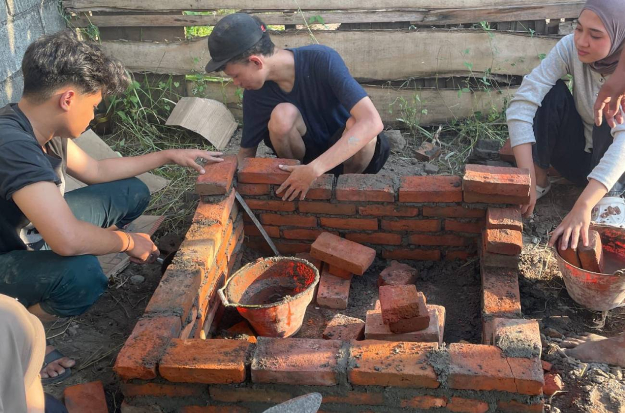 KKN Terpadu Mahasiswa Umsida membuat rocket stove untuk meminimalkan asap dari pembakaran sampah. (Foto: dok.Umsida)