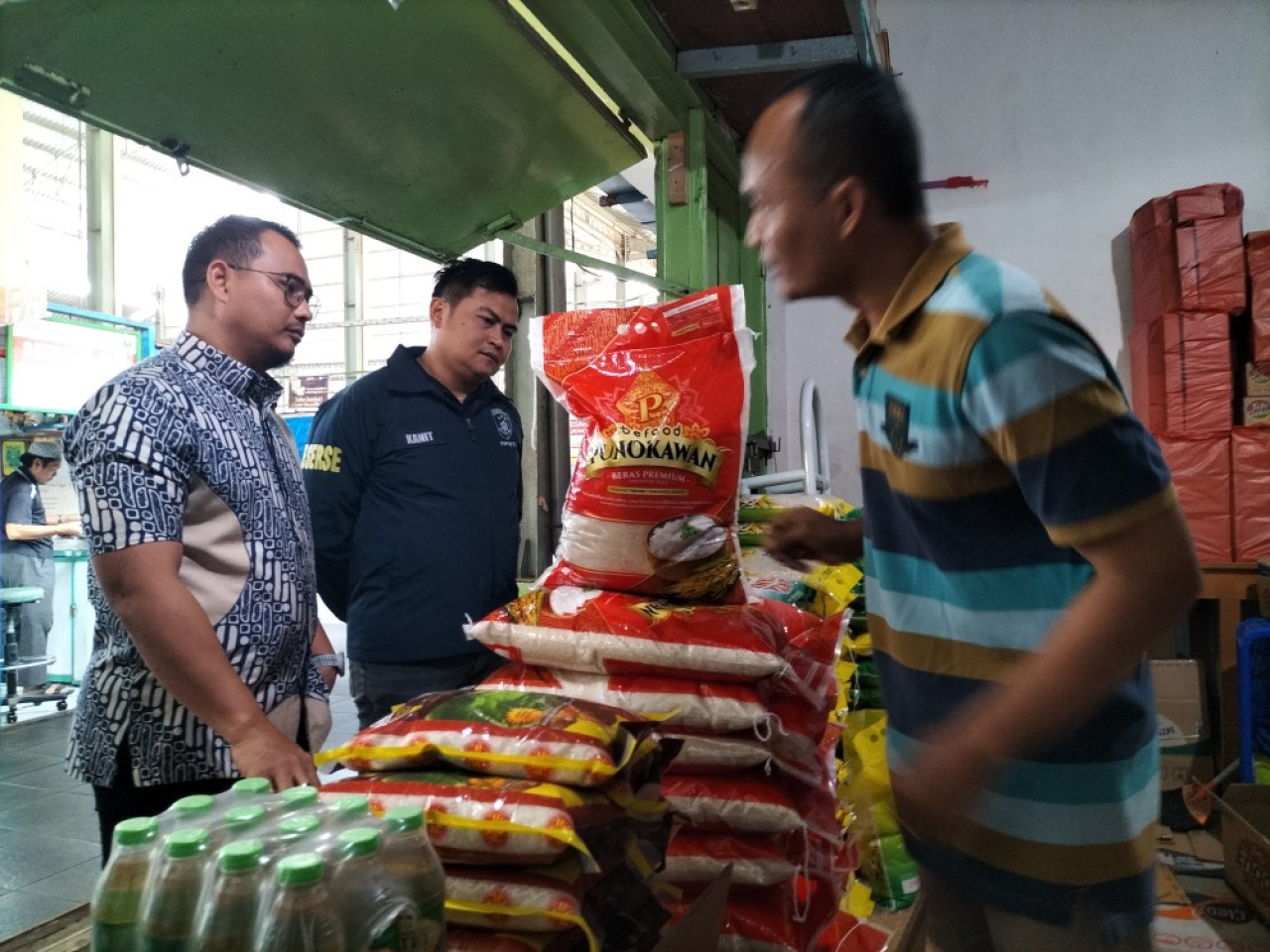 Pemimpin Bulog Cabang Malang, M. Nurjuliansyah Rachman (kiri) bersama Satgas Pangan Polresta Malang Kota berdialog dengan pedagang di Pasar Bunulrejo, Kota Malang. Foto: Jatimkini/Bagus Suryo