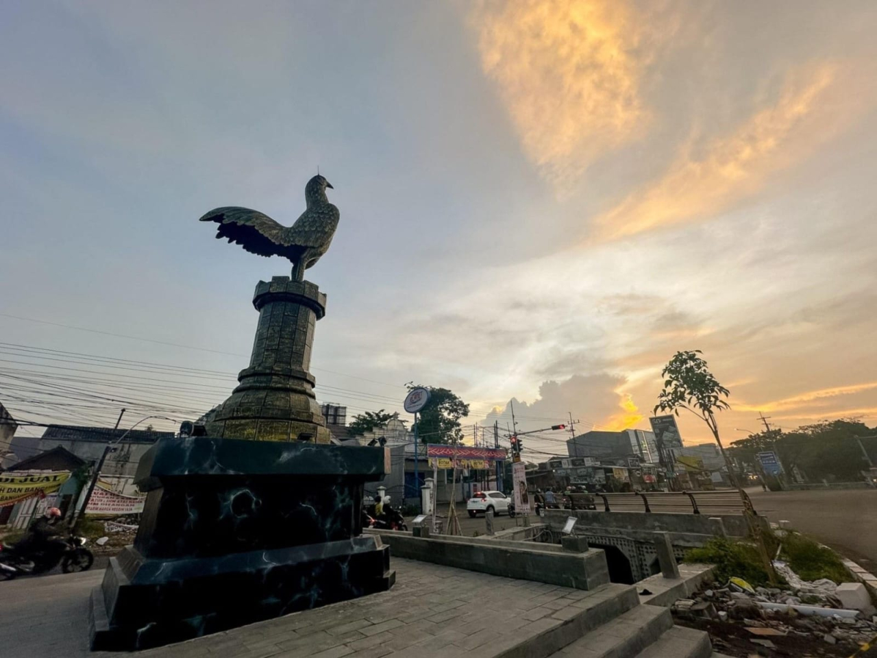 Patung ayam jago di persimpangan Jalan Lidah Wetan, Surabaya, menjadi tetenger kawasan yang dikaitkan dengan petilasan Sawunggaling, tokoh legenda Kota Surabaya. ( Foto : Istimewa )
