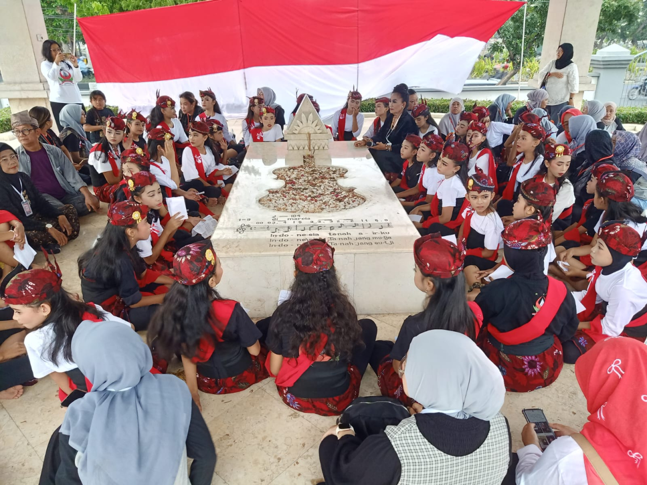 Anak-anak kirim doa kepada WR Supratman sambil menyanyikan Indonesia Raya 3 Stanza karya pahlawan nasional tersebut. ( Foto : Rokimdakas /Jatimkini.com )